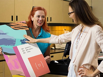 Clerk showing final printed poster to customer